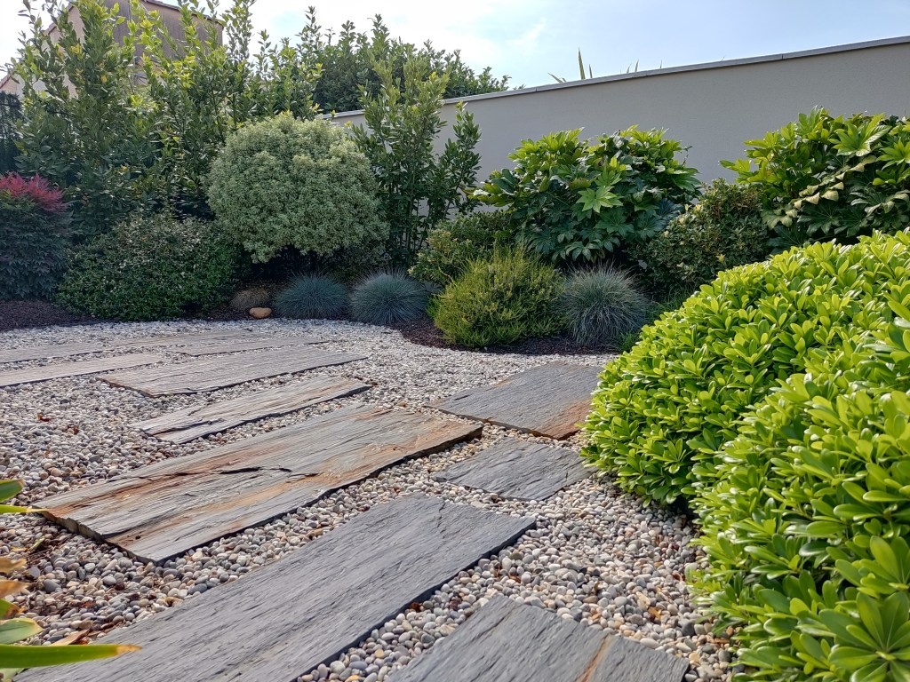 Jardin avec terrasse et espaces de détente aménagés par Camps Paysage